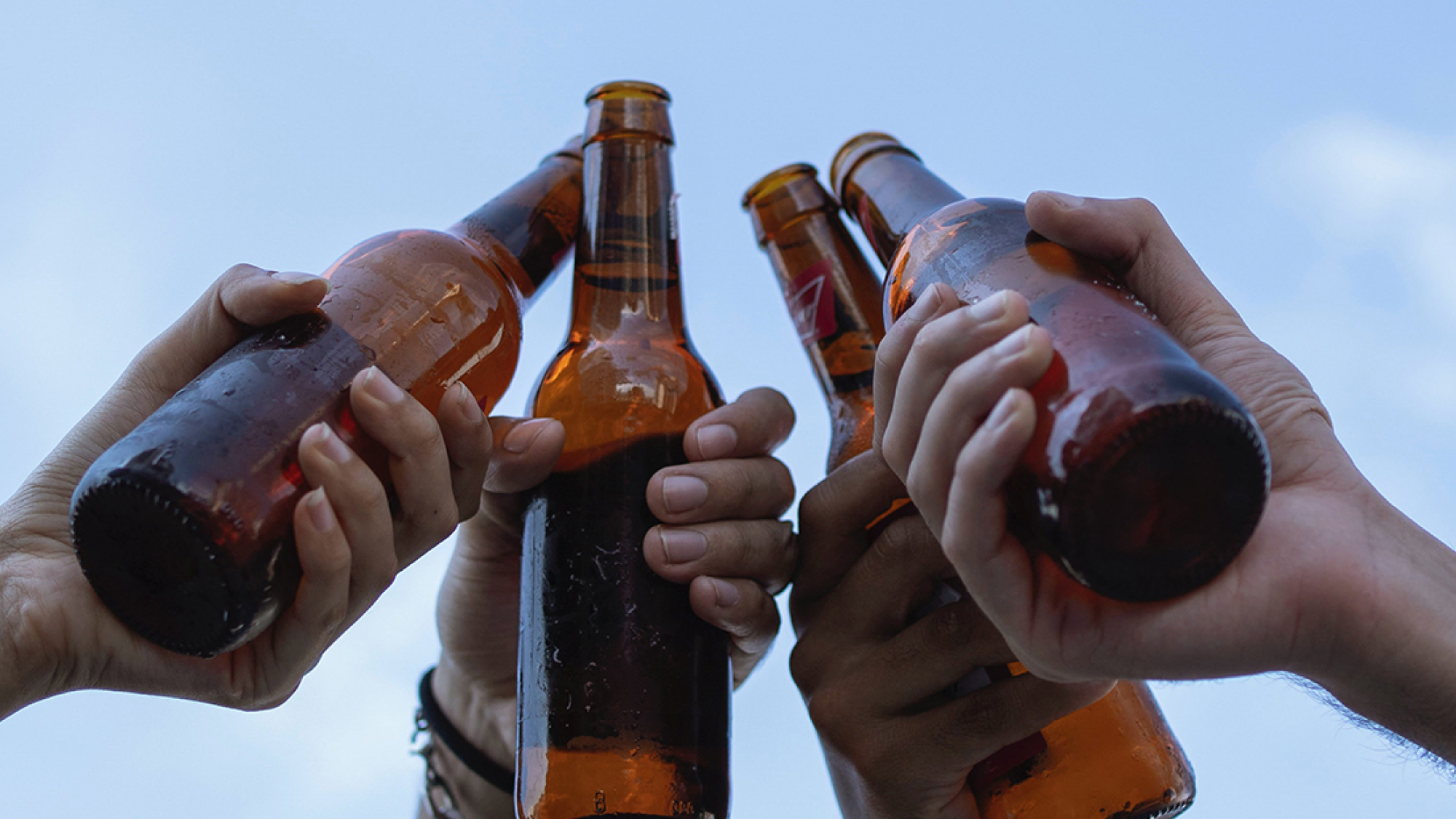 hands cheering with beer bottles