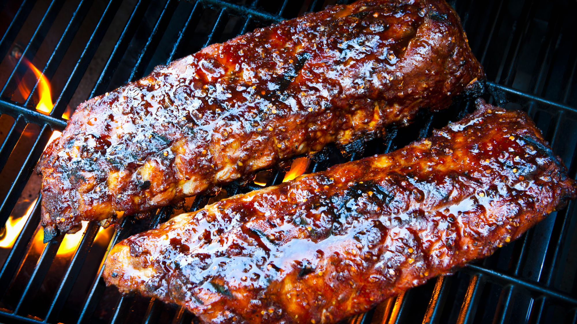 close up of ribs being cooked on a grill