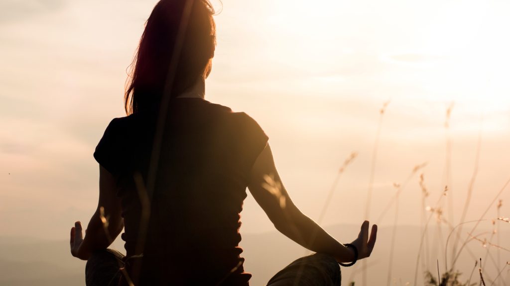 silhouette of a woman meditating