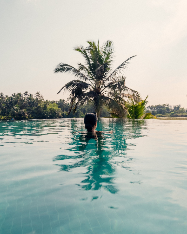 hotel guest in pool with palm trees