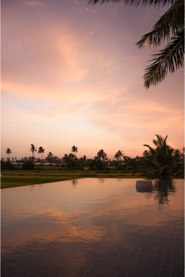 view of hotel pool at sunset