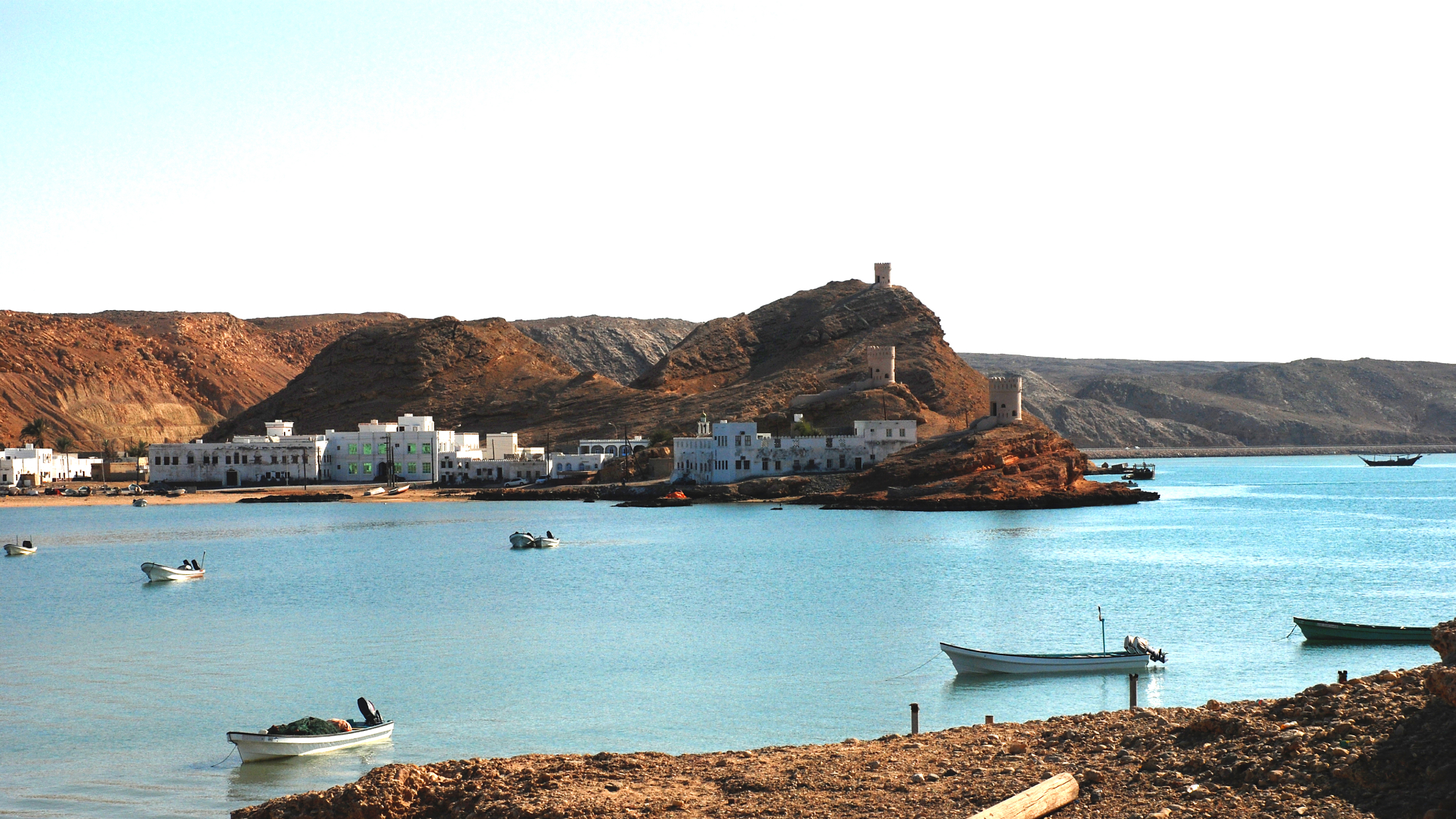 View of floating boats in the lagoon with the rocks and hills in the background