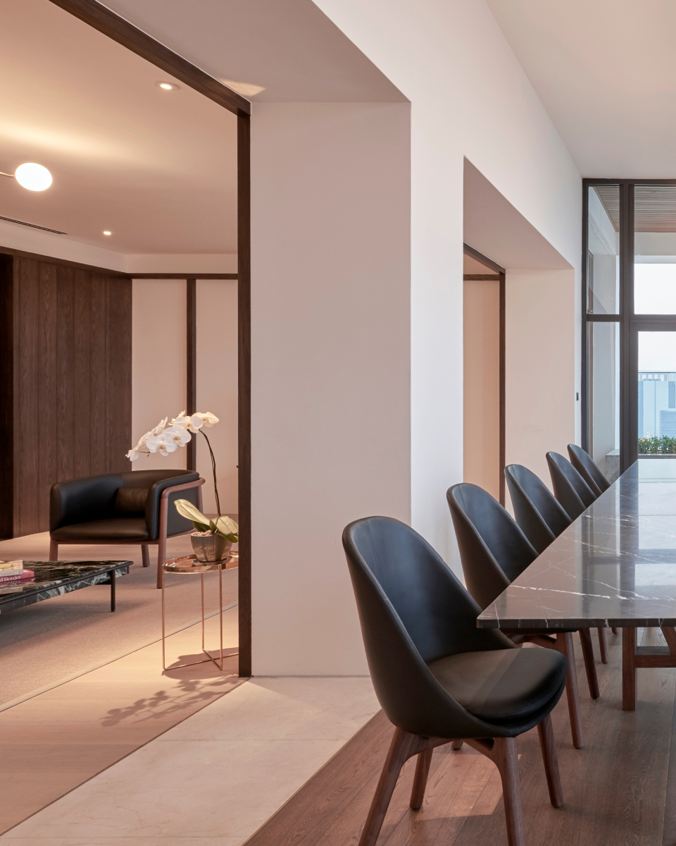 long marble tables with chairs and a living area with furniture