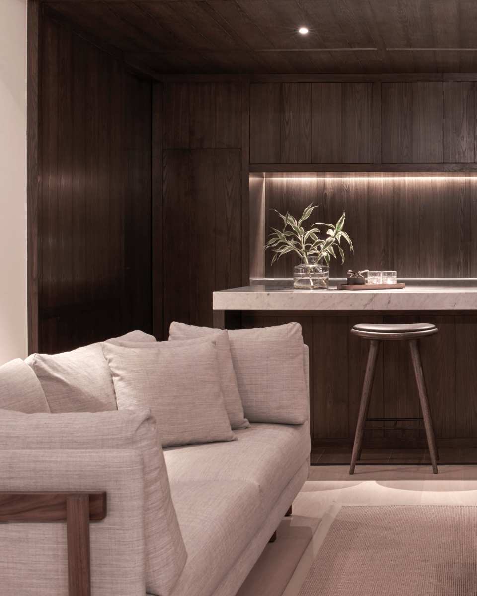 Light grey couch and a marble table with a stool