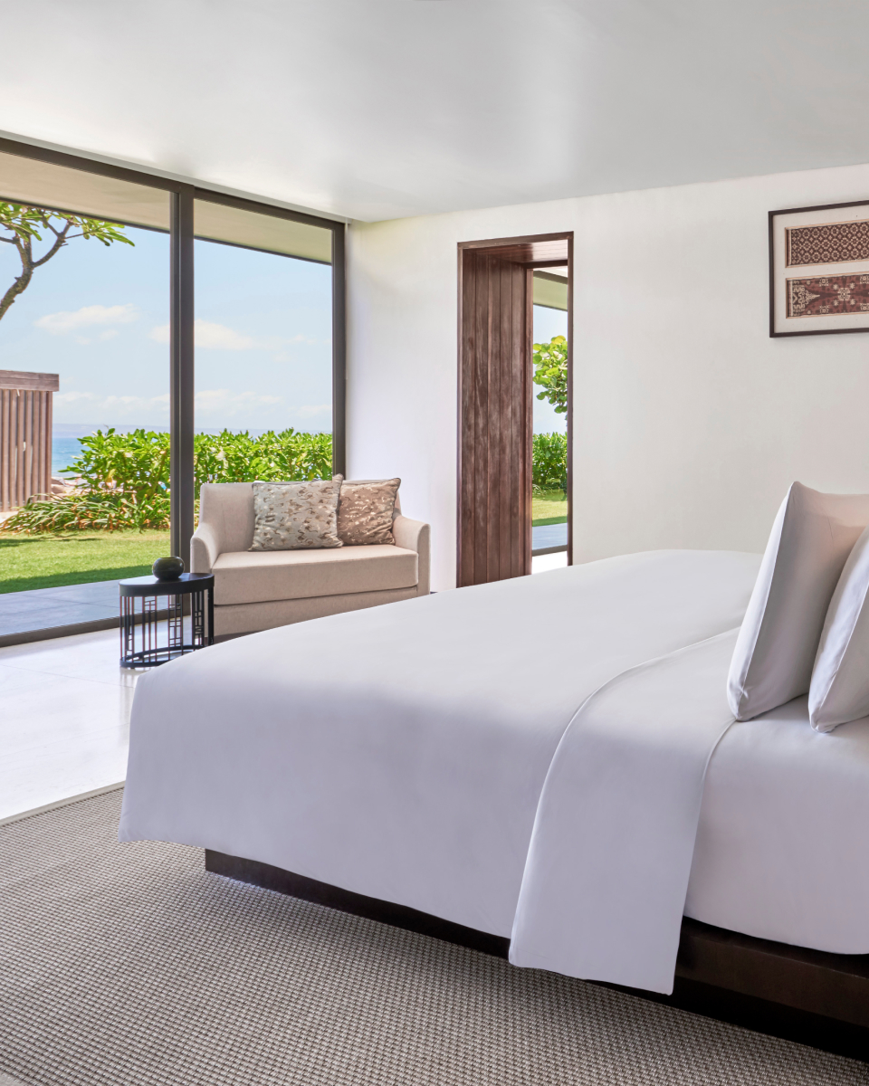 King bed with white comforter and long windows