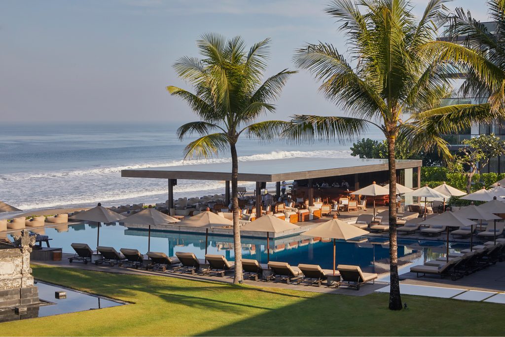 Pool bar with palm trees and ocean.