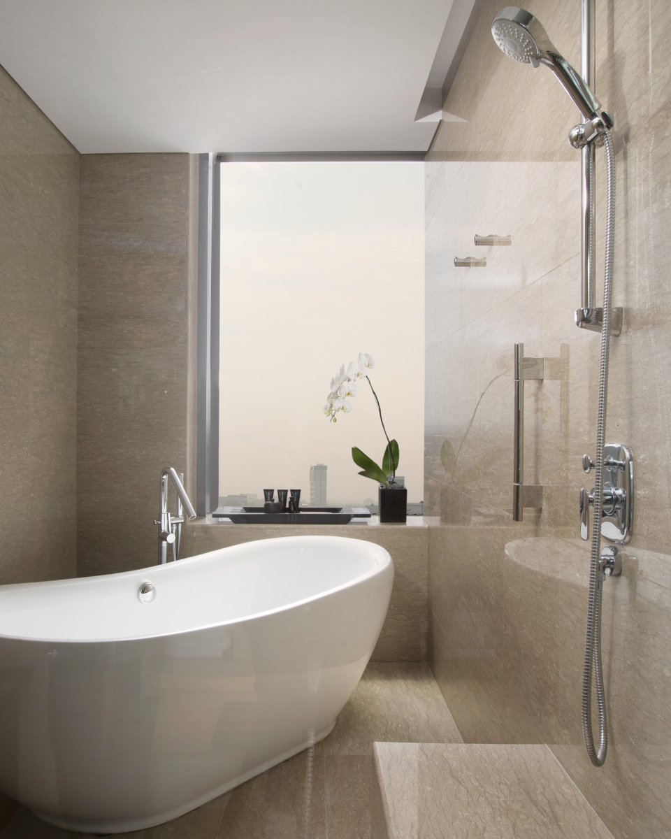 hotel room bathroom with white tub and orchid flower