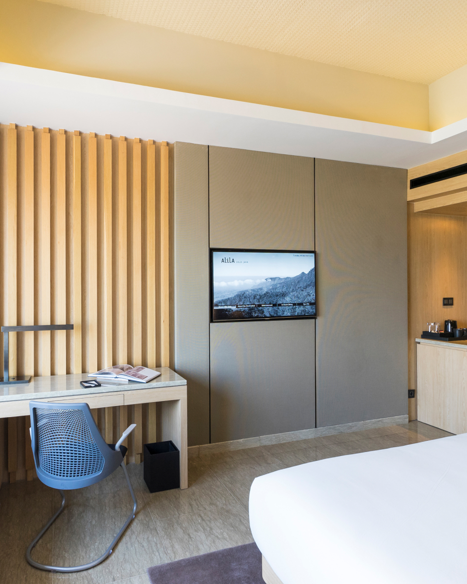 interior hotel room with TV, desk and wooden accents