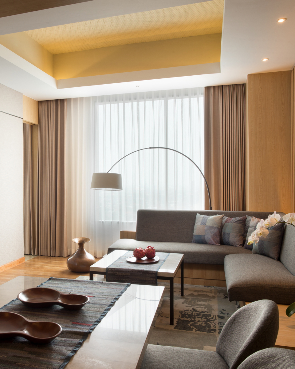 interior hotel room with overhead lamp, couch, coffee table and dedicated dining area