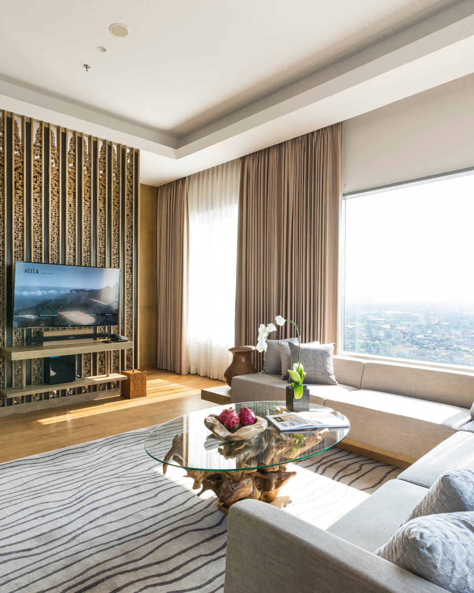 interior hotel room with TV, couch and coffee table